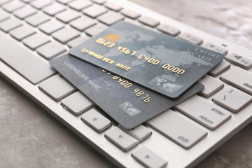 Credit cards with computer keyboard on grunge background, closeup. Concept of online banking