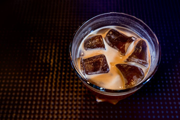 Alcoholic cocktail with ice at wooden bar counter. Restaurant.