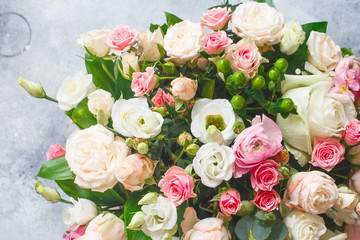 Bouquet of beautiful flowers with peonies, roses and eustomas in the papper gift box in front of grey grunge background. Closeup picture. Valentine's Day. Mothers Day