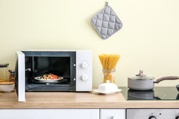 Modern microwave oven in kitchen - obrazy, fototapety, plakaty