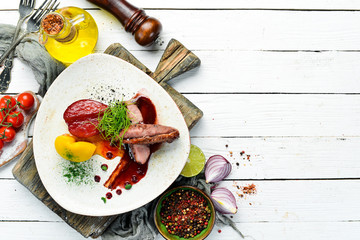 Baked duck fillet with pear and cranberry sauce. Top view. free space for your text. Rustic style.