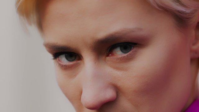 Extreme close up shot of the green eyes of an angry woman. Serious scary look. Selective soft focus, isolated slow motion shot