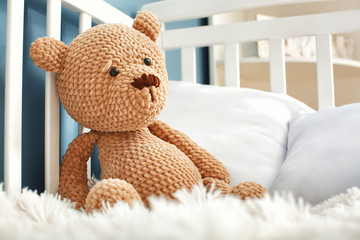 Cute toy bear in baby crib