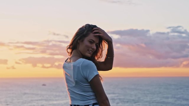 Laperouse, Australia - Beautiful Young Woman Happy And Smiling While Looking On The Camera With Beautiful Sunset and Bright Ocean in The Background - Wide Shot