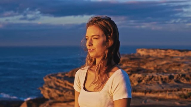 La Perouse, Australia - A Beautiful Young Woman Looking at the Calm Sea During Sunset - Wide Shot
