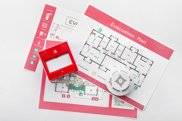 Evacuation plans, smoke detector and manual call point on white background