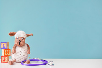 Stethoscope and baby toy on table