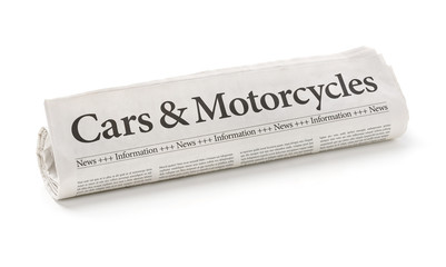 Rolled newspaper with the headline Cars and Motorcycles