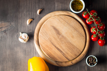 Wooden Cutting Board with Fresh Herbs and Raw Vegetables on Rustic Wood Table. Top view. Cooking background.
