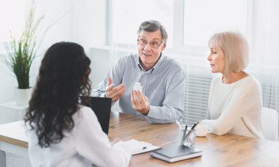 Mature couple asking their doctor about pills