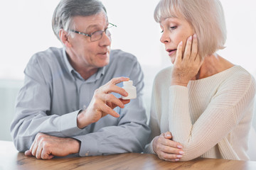 Mature man giving his wife some pills