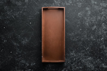 Old wooden box on black stone background. Top view. Free space for text.