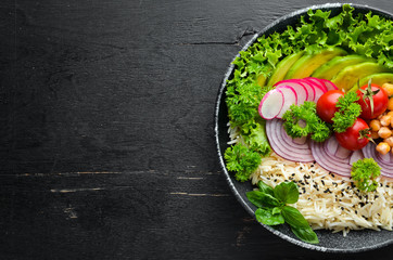 Vegan, detox Buddha bowl recipe with rice, avocado, tomatoes and chickpeas. Dishes menu. Free copy space. Top view.