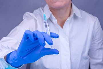 Doctor in a medical glove with a syringe. Close-up. Vaccinations. Medicine. Treatment.