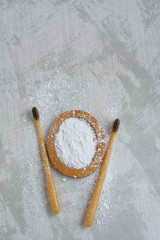 bamboo eco friendly toothbrushes and tooth powder, zero waste tooth cleaning set on concrete background