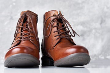 Pair of brown leather womens boots on the white background