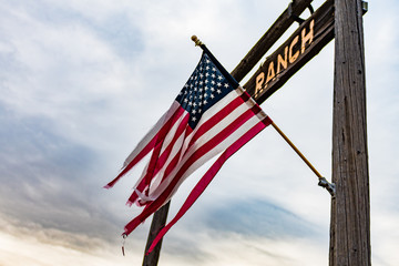 A woven USA flag flies in the entrance arch of a ranch in Oregon