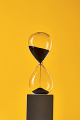 Hourglass on the yellow background with copy space. Concept of running out of time and deadline