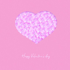 Heart made up of spring flowers on a pink background. Happy valentines day background.