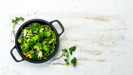 Green vegetables stewed in a frying pan. Broccoli, beans, green peas. Top view. Free space for your...