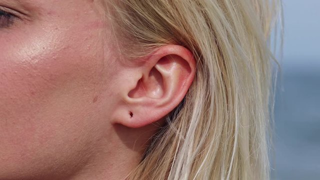 Close up shot of wound hole in ear lobe of blonde woman,macro view