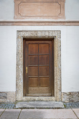 Old wooden door in white building in europe
