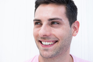 Obraz premium Close up handsome young man smiling and looking away by white background