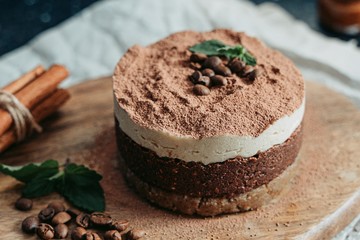 Tiramisu on a wooden plate. Coffee and cinnamon. Raw dessert