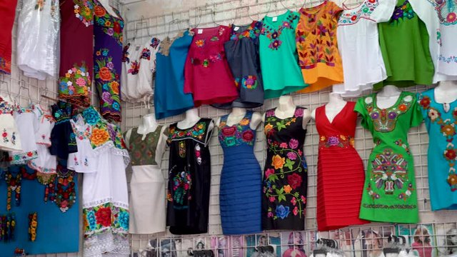Camera panning left showing colorful designer huipil blouses indigenous to Merida, Yucatan, Mexico.