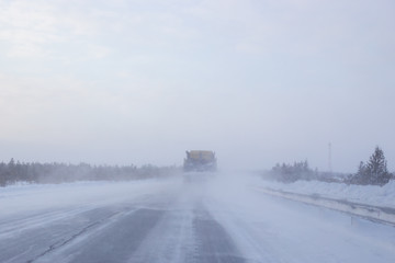 cars go on a winter road with poor visibility, weather and snowstorm