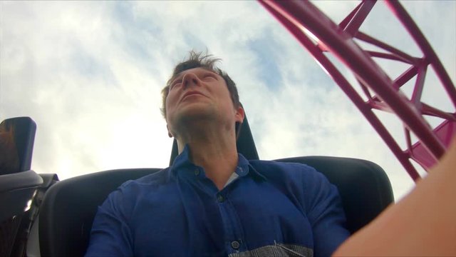Inside high-speed rollercoaster, on-ride camera of happy thrilled man