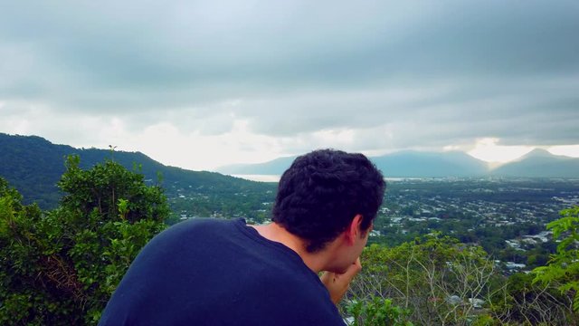 photographer enjoying a peaceful morning taking shots of cairns australia with a cloudy sky and beautiful mountains in the background, slow motion