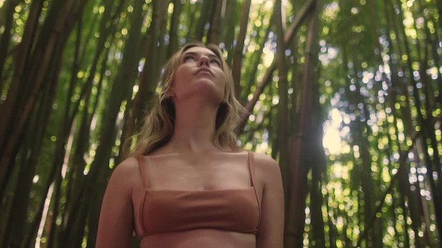Caucasian model peering into beautiful bamboo forest in Maui Hawaii in slow motion.