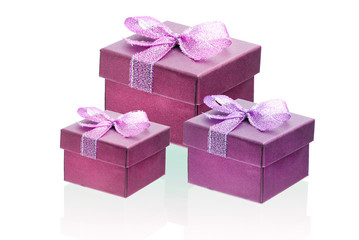 Three cherry color gift boxes isolate on a white background, close-up, reflection