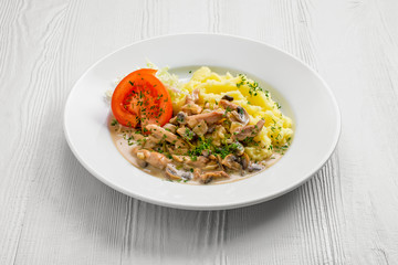 Plate with chicken goulash, mushroom, mashed potato and tomato cabbage salad