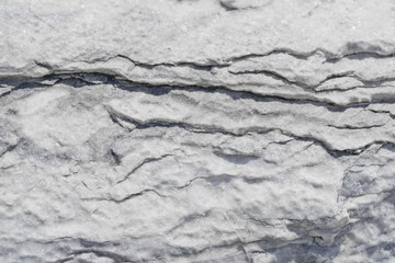 The texture of a white marble slab with breaks and cracks.