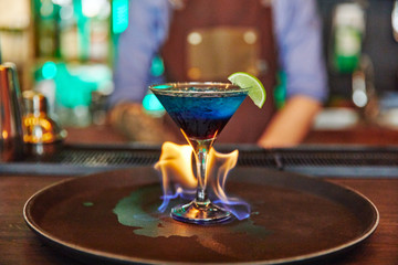 cocktail with lime burning fire in a glass goblet, alcohol