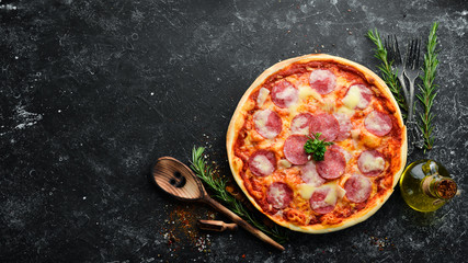 Traditional pizza with salami sausage and mozzarella. Top view. free space for your text. Rustic...