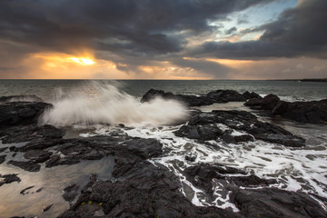 The shore of the Atlantic Ocean with cooled lava during a storm against a stormy sky