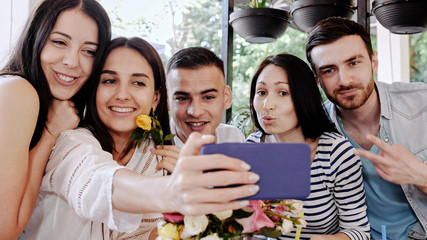 Group of friends makes selfie in at cafe