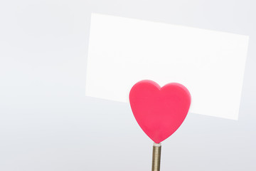 A red heart shape paper holder and a white paper