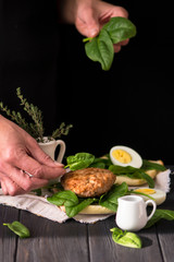 fried cutlet and spinach sandwich on dark wooden background