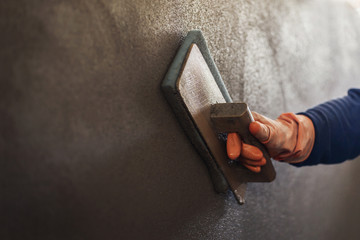 Plastering concrete to create industrial worker wall background with plastering tools, home improvement, quality concepts