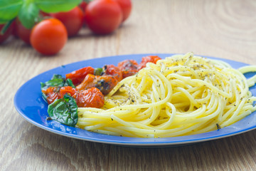 Pasta with tomatoes on blue plate