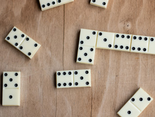 The game of dominoes. Pieces of dominoes on a brown wooden table background