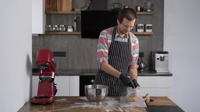 The cook has prepared a dough for cupcakes or gingerbread. The cook removes the dough for whatever it is.