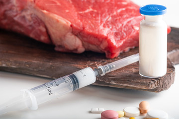 Injection of antibiotic into raw meat. Chemical experiments in food production.
