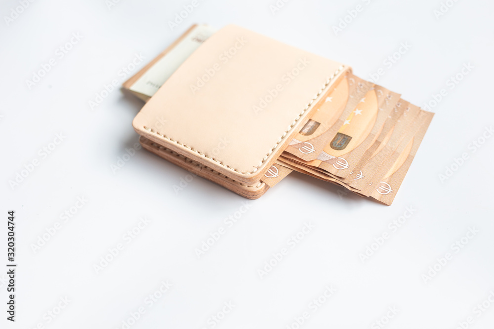 Wall mural Euro money bill in leather bifold wallet on white background