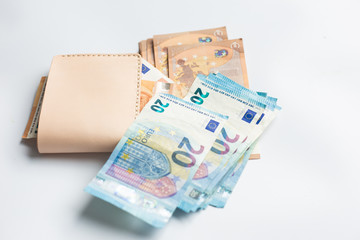 Euro money bill in leather bifold wallet on white background