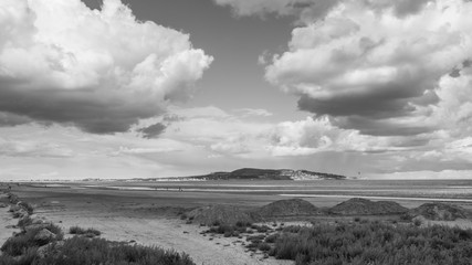 Black and white shot of Dollymount Strand, County Dublin, Ireland. Howth Head peninsula can be seen in the distance.